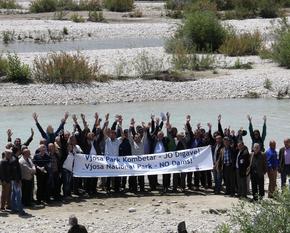 Menschen demonstrieren mit einem Banner für den Vjosa Nationalpark.