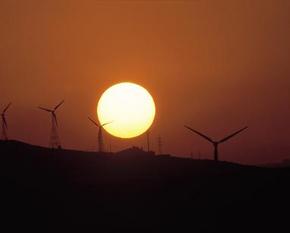 Wind turbines in front of the setting sun.