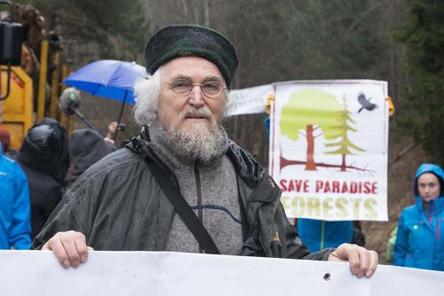 The German scientist Professor Dr. Hannes D. Knapp with activists and banners in front of a forestry machine