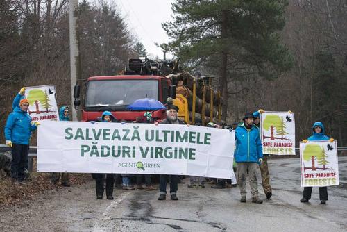 Protesters with placards block a wooden truck in Romania.