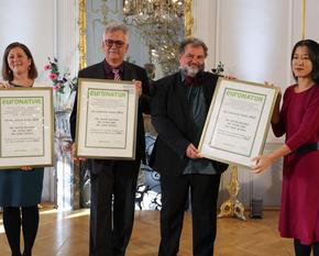 Die Preisträger bekommen die Urkunden überreicht.