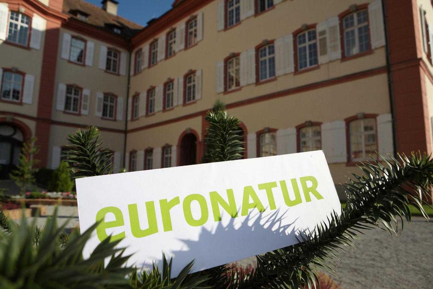 Schild mit EuroNatur-Schriftzug vor Schloss Mainau