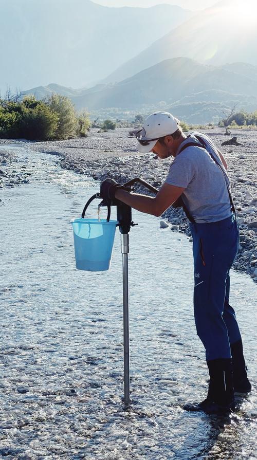 Hydrobiologist with pump and bucket