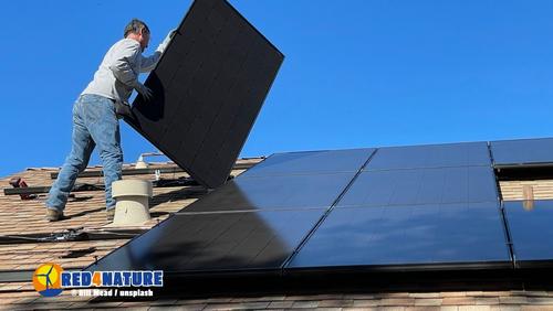 Installation von Solarpanels Mann setzt Solarpanels aufs Dach