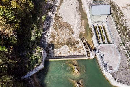 Luftbild eines Kleinwasserkraftwerks am Fluss Ugar in Bosnien-Herzegowina. Das Flussbett unterhalb der Staumauer ist weitgehend ausgetrocknet und die Fischtreppe ist komplett trocken.