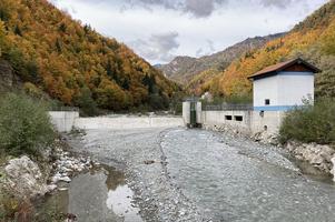 Kleinwasserkraftwerk mit Damm an einem Fluss