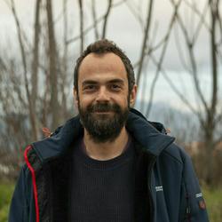 bärtiger Mann vor unbelaubten Bäumen