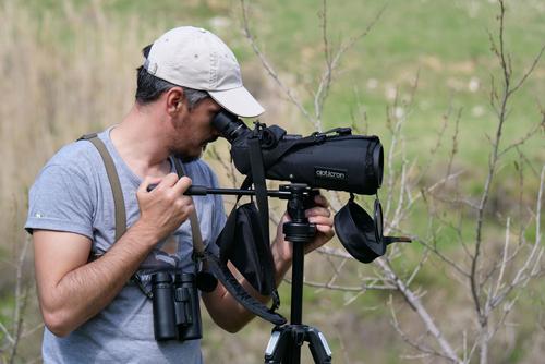 Ornithologist looks through the spotting scope