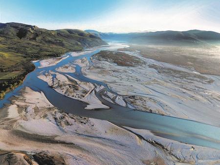 Aerial view of the Vjosa with sand and gravel banks in a wide valley.