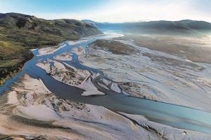 Aerial view of the Vjosa with sand and gravel banks in a wide valley.
