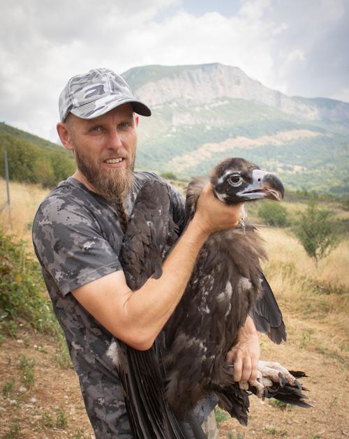 Vogelschützer hält Geier auf dem Arm