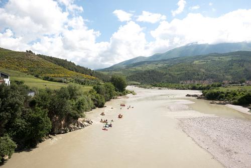Inflatable boats and kayaks travel downstream on the Vjosa.