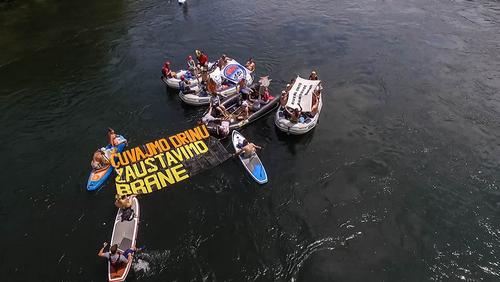 Boats and paddlers with a poster