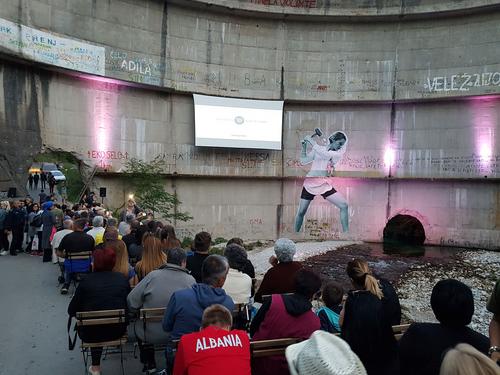 People sitting below the Idbar dam to watch the film