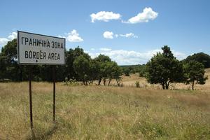 Grenzschild auf einer mit Bäumen bestandenen Wiese