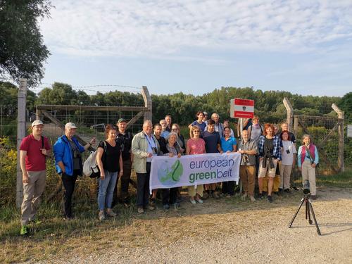Group picture with Green Belt banner at a border fence at the Austrian border.