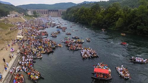 Viele Boote und Flöße vor einem Staudamm an der Drina