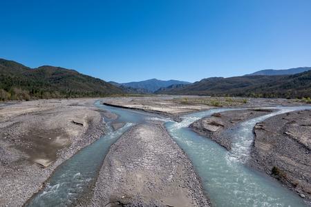 The river Sarantaporos flows through a wide valley.