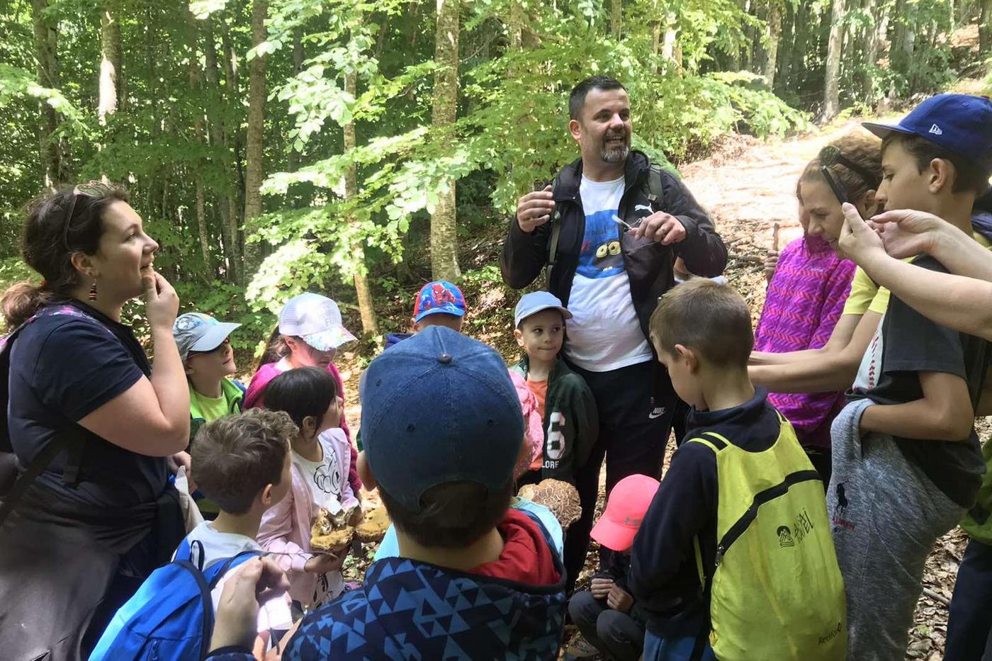 Naturschützer mit Schulkindern im Wald
