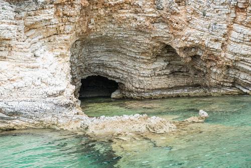 Höhle in den Klippen und kristallklares Meerwasser