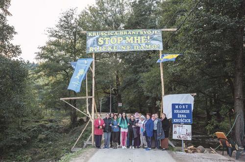 The Brave Women of Kruscica block a bridge with protest banners hanging from it.