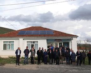 People stand in front of a house and present a solar roof.