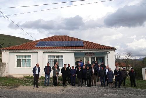Solardorf Kute Menschen vor Haus mit Solardach