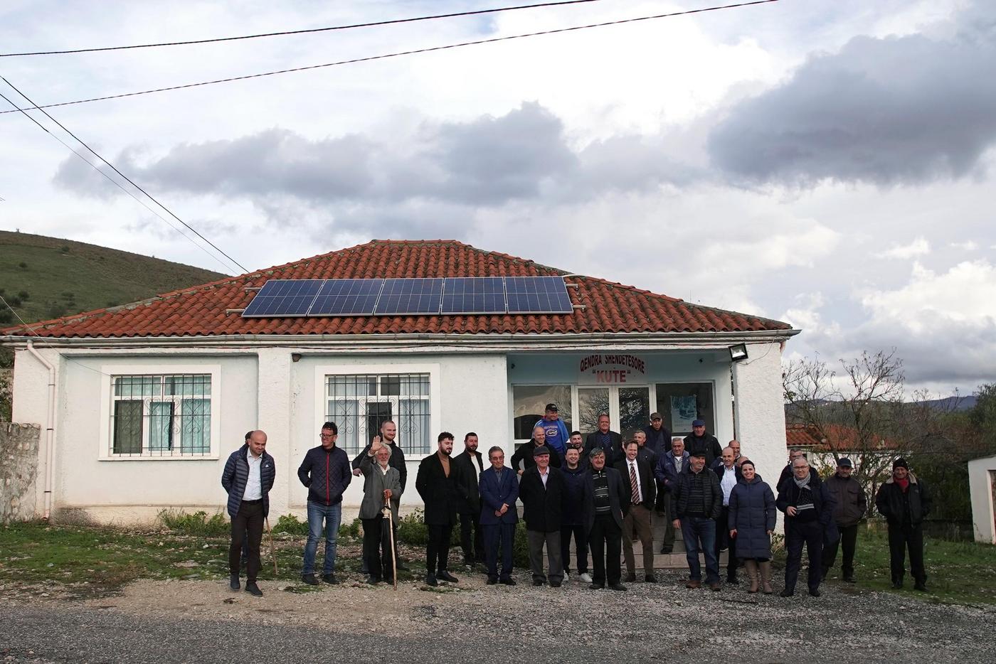 People in the front of a building with a solar roof