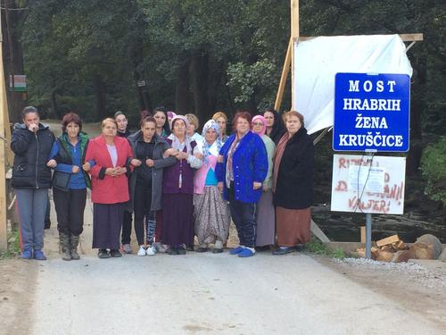 Many women stand close together on a bridge and demonstrate unity.