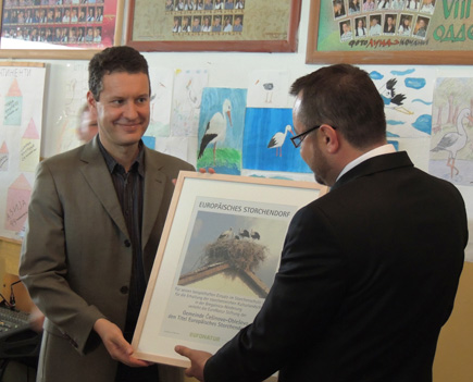 EuroNatur-Geschäftsführer Gabriel Schwaderer (links) überreicht dem Bürgermeister der Gemeinde Češinovo-Obleševo die Auszeichnung „Europäisches Storchendorf“.