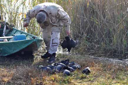 Jäger mit Boot und toten Blässhühnern