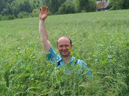 Bauer winkt im Mischkultur-Feld