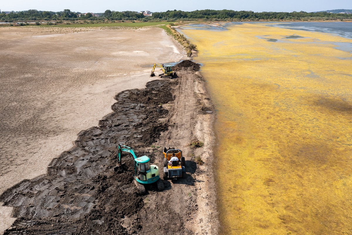 Zwei Bagger und ein Radlader restaurieren einen Damm der Saline Ulcinj.