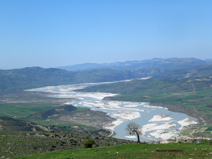 Broad natural wild river with sandbanks in a mountain landscape