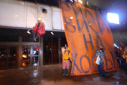 Demonstranten befestigen ein Banner an einem Gebäude