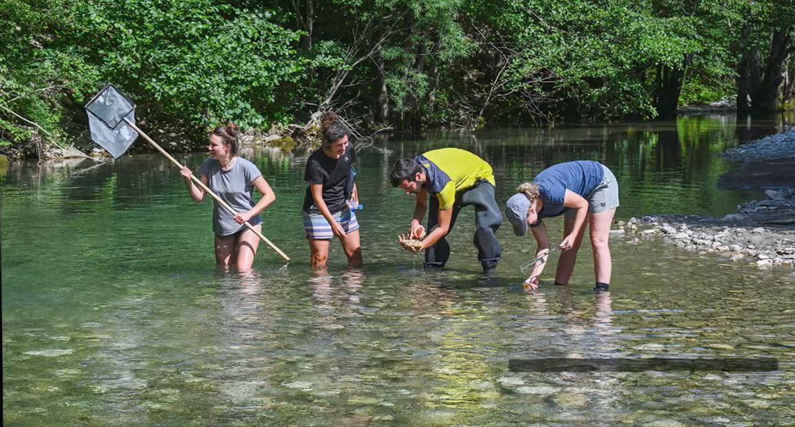 People standing in the river with a landing net